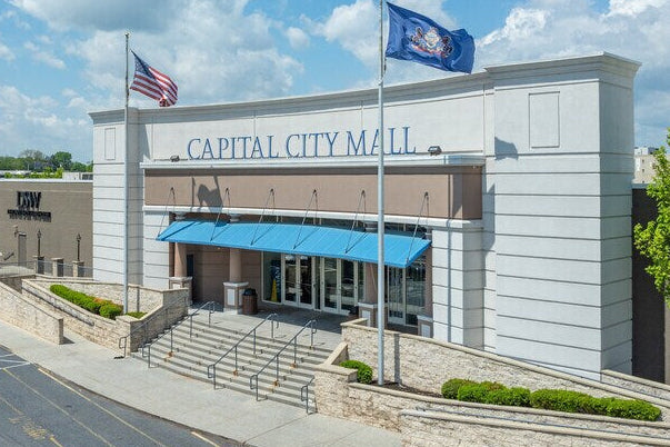 Capital City Mall building with American and Pennsylvania flags on a clear day